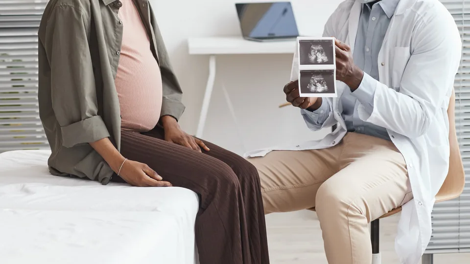 An expectant mother and her doctor reviewing a scan